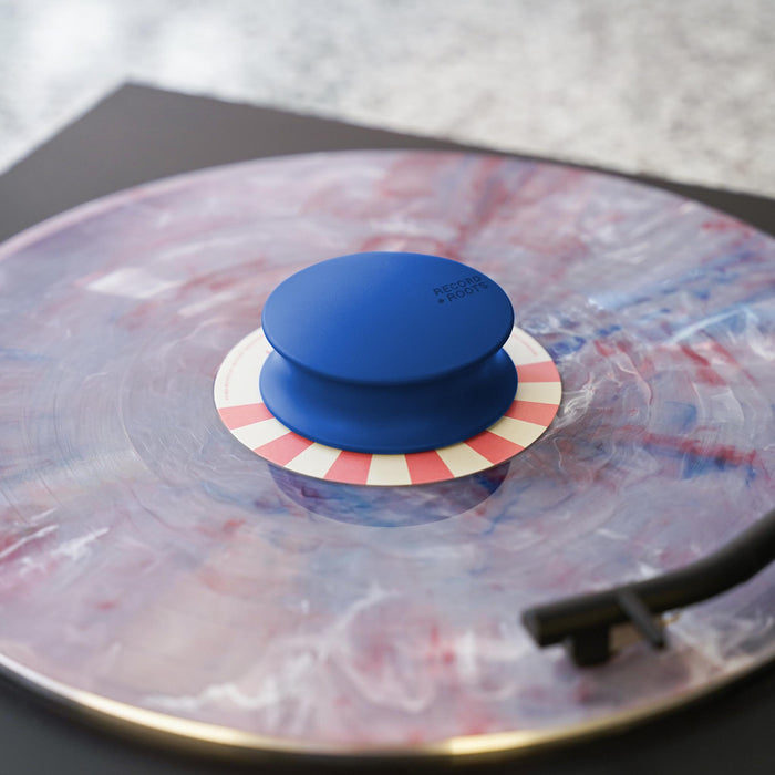 Blue Record Roots weight on a record playing on a turntable