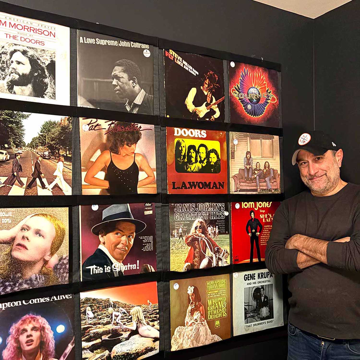 Collector beside a wall of favourite albums in Record Roots frames