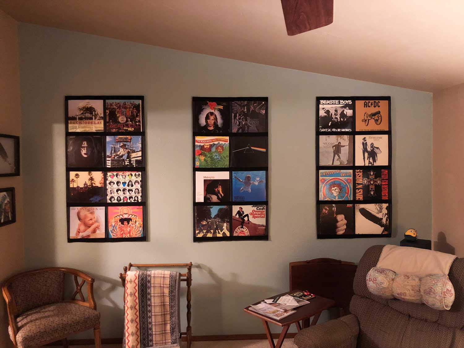 Three vinyl record display frames above living-room seating