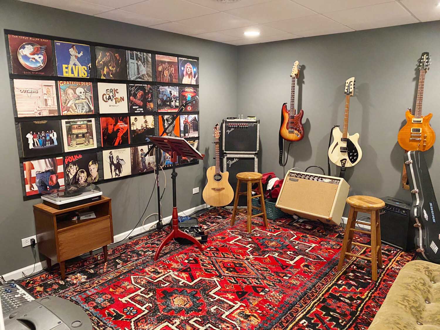 Record display frames alongside guitars and a turntable in a music room