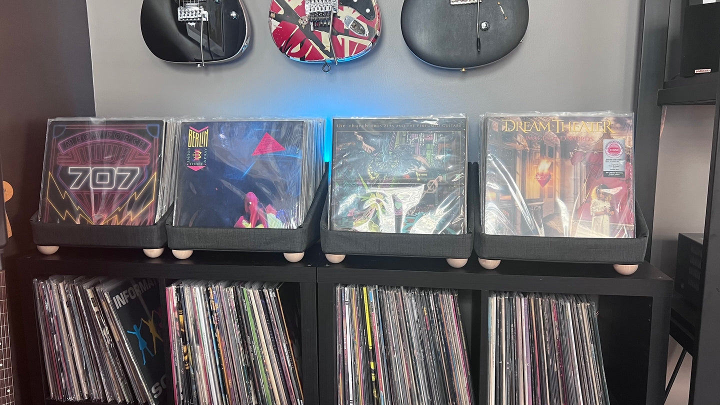 Four tabletop storage containers beneath guitars in a listening room