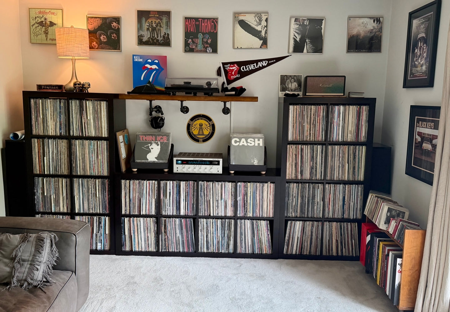 Two tabletop storage containers beside a receiver in a vinyl listening room